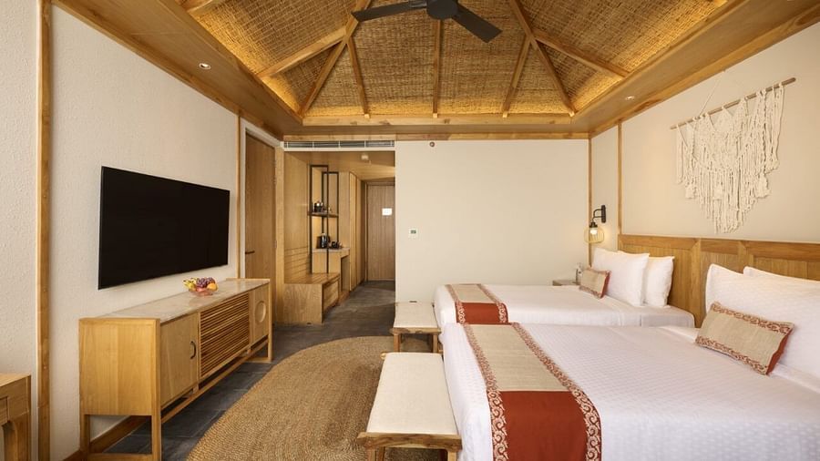 A twin-bed room in Chitwan featuring wooden ceiling, fan, TV, and rustic decor - Royal Tulip, Chitwan