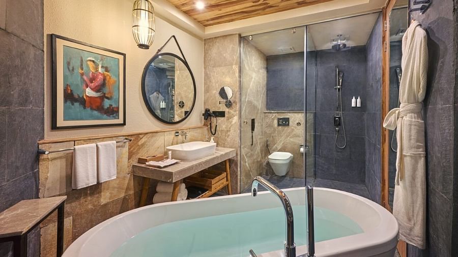 Modern bathroom with freestanding bathtub, twin vanities, round mirror, and walk-in shower - Royal Tulip, Chitwan