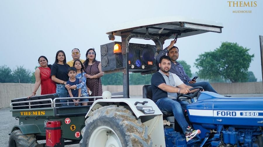 Group of eople enjoying a tractor ride surrounded by trees at Themis Mudhouse - A Nature's Retreat Resort & Wellness