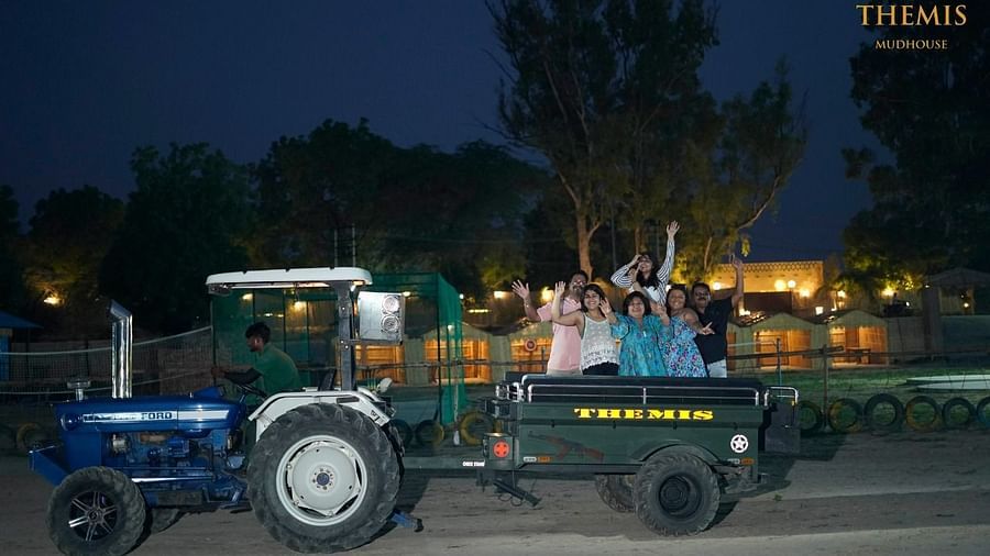 People on a tractor ride at inflated trampoline surrounded by trees at Themis Mudhouse - A Nature's Retreat Resort & Wellness