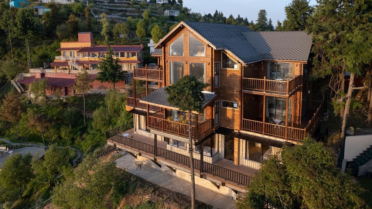 An image of a lush green area with several buildings and dome style cottages  -  Avalon Cottages, Kanatal