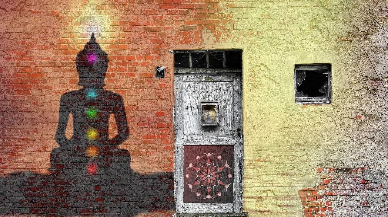 A colourful graffiti painting of Buddha on a textured brick wall, bringing a touch of artistic.