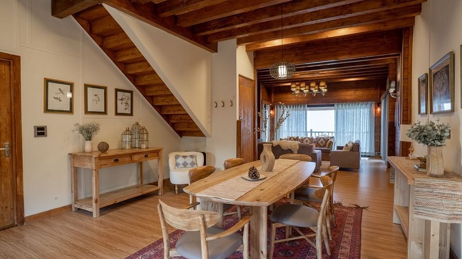 An image of dining space with table and chairs and stairs leading to the attic - Avalon Cottages, Kanatal