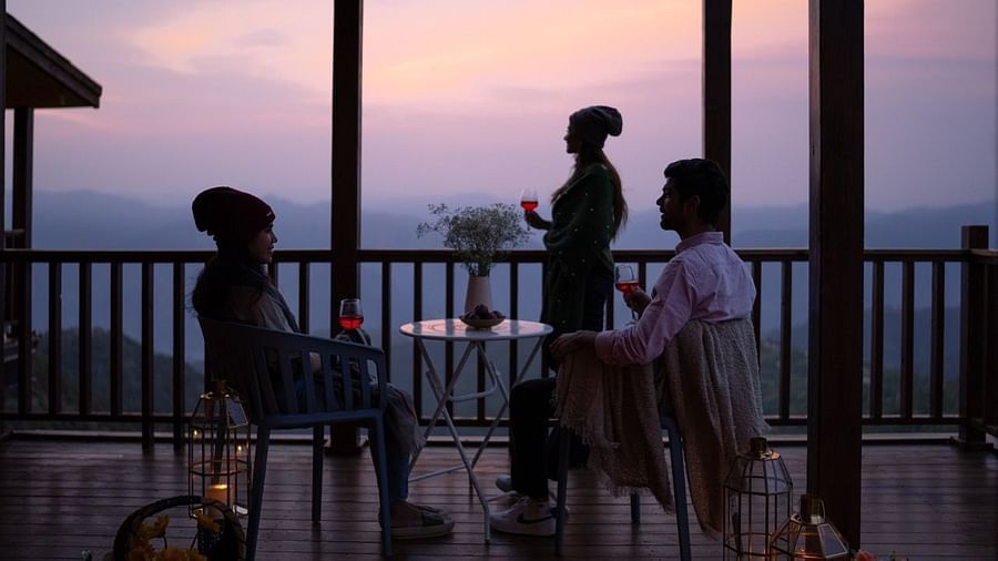 An image of evening view from the patio with group of people sitting and enjoying at the table | Avalon Cottages, Kanatal