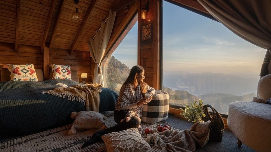 An image of woman enjoying the view with a cup of coffee