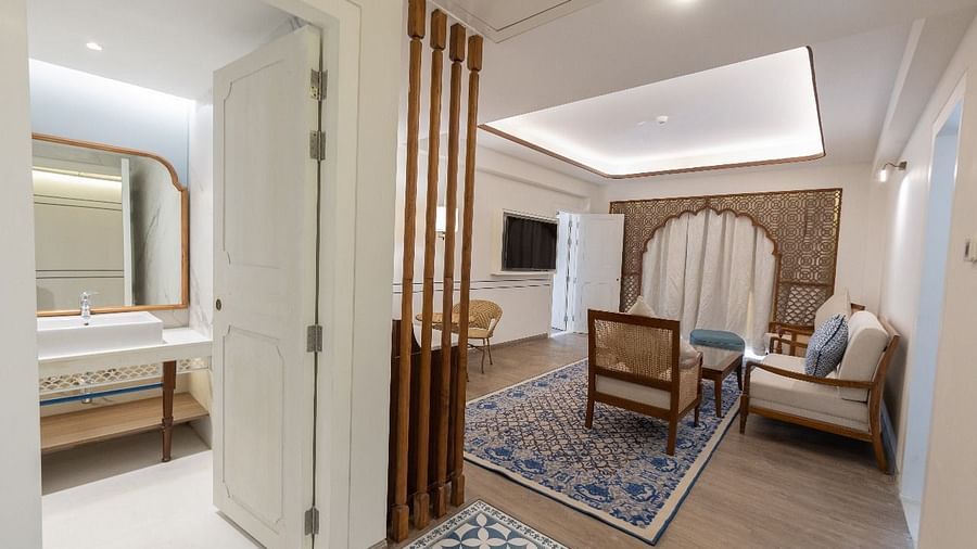 The living area at the Ananta with a door opening to the bathroom with a wide mirror inside it at Bhagirathi by RDB Atishay.