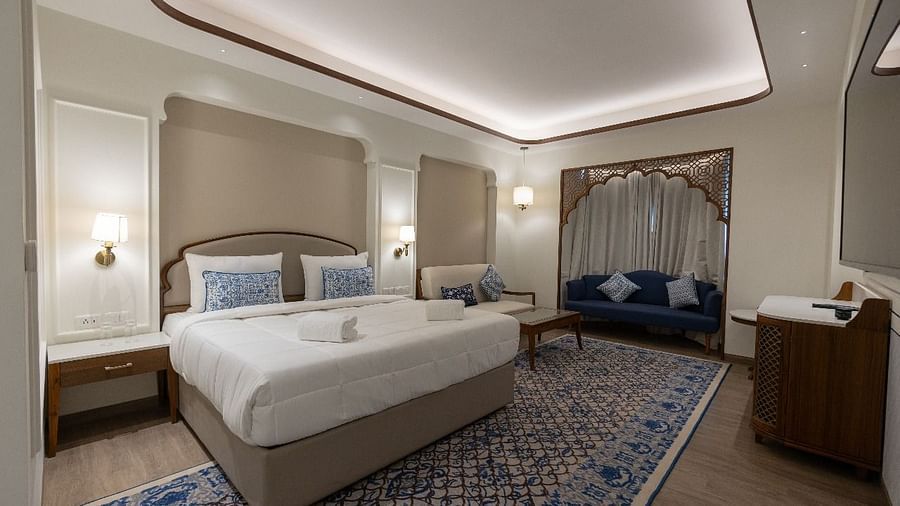 Corner view shot of the Mandakini Room featuring a plush double bed along with a long patterned carpet on the floor at Bhagirathi by RDB Atishay.