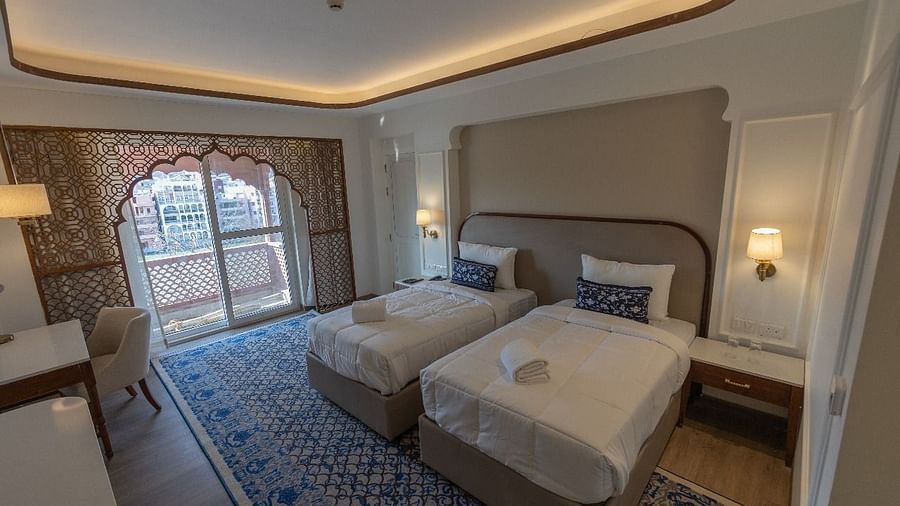Top angle shot of a twin Jalrupa bedroom with a balcony in the corner at Bhagirathi by RDB Atishay.