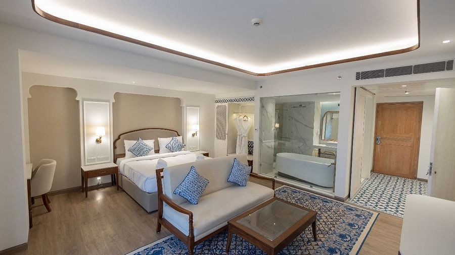 Full view shot of the Purna Room at Bhagirathi by RDB Atishay featuring a double bed and a couch in front of it at Bhagirathi by RDB Atishay. 
