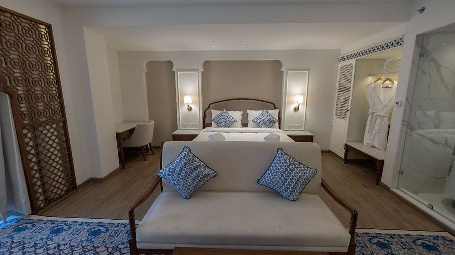 Front view shot of the Purna bedroom featuring a small couch in front of the double bed at Bhagirathi by RDB Atishay.