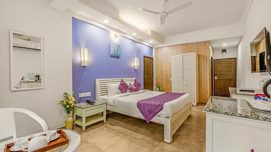 Image of a room with a bed, seating area and a television at Calux Joia Do Mar Resort, Goa.