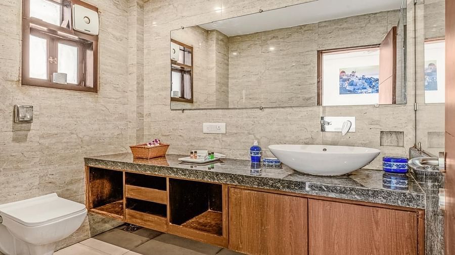 Image of the washroom at Grand Room with a sink and toilet at Calux Joia Do Mar Resort, Goa.