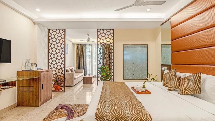 Side view of Grand Room with a bed and television in front at Calux Joia Do Mar Resort, Goa.