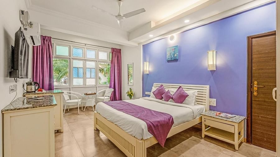 Premium Room with a bed and a television in front at Calux Joia Do Mar Resort, Goa.