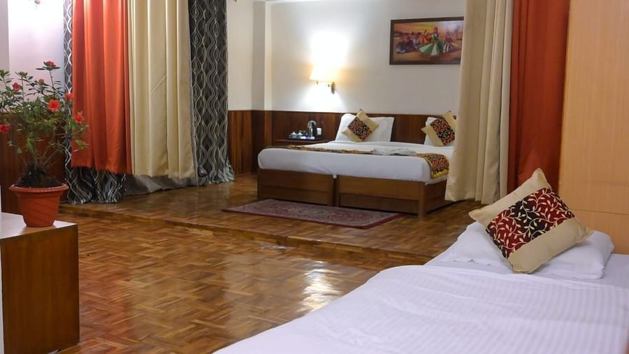 An image of the family room featuring two beds, bed side tables, indoor plants, and decorative lighting - Sumitel Chiminda, Pelling