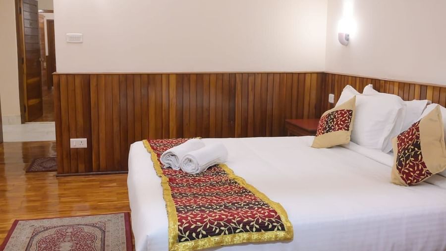 An image of a room with a queen size bed, bed side tables, lamps, and a rug - Sumitel Chiminda, Pelling