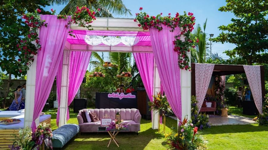 A beautifully decorated outdoor wedding canopy or mandap with pink and white flowers and fabric, set on a green lawn | Grande Pavillion | Grand Bay Resort and Spa