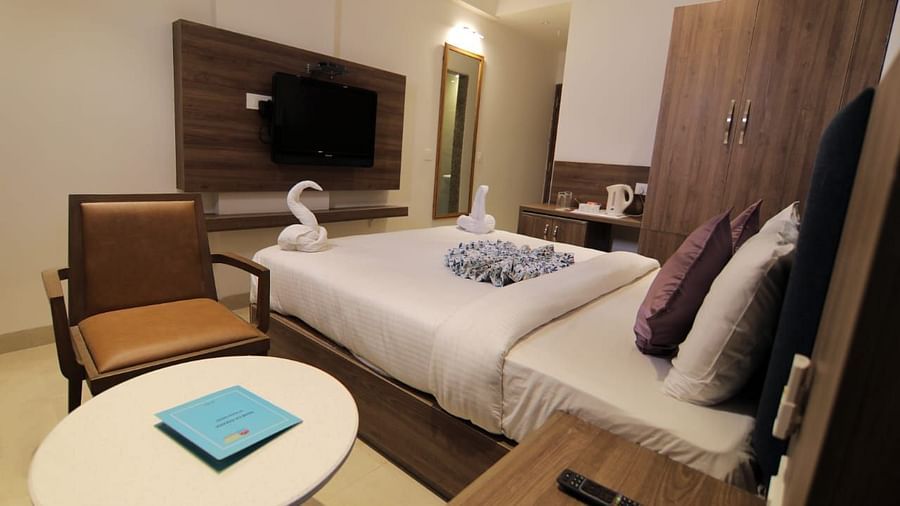 Room at Hotel Mumbai House Express, Udaipur with a double bed, a television and a coffee table and chair