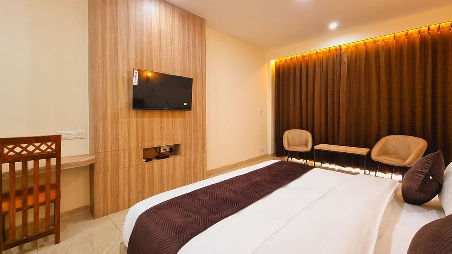Deluxe Room with bed,seating area, study table and chair on the corner at Pines and Peaks, Dalhousie 