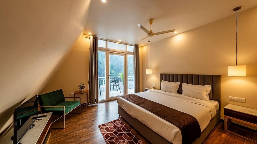 A hotel room showing a bed, a TV, and a door to the balcony.