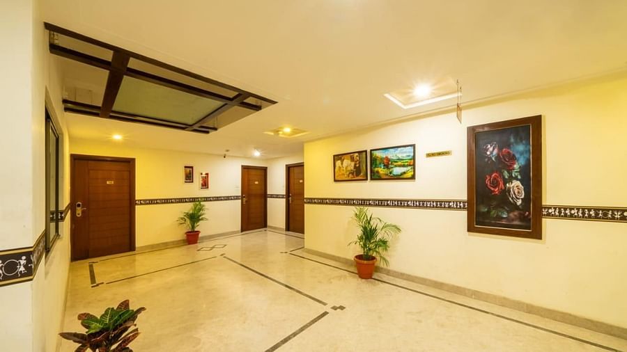 A long hotel corridor with elegant flooring and artwork leads to various rooms, ensuring easy navigation at Lords Midtown Suites.