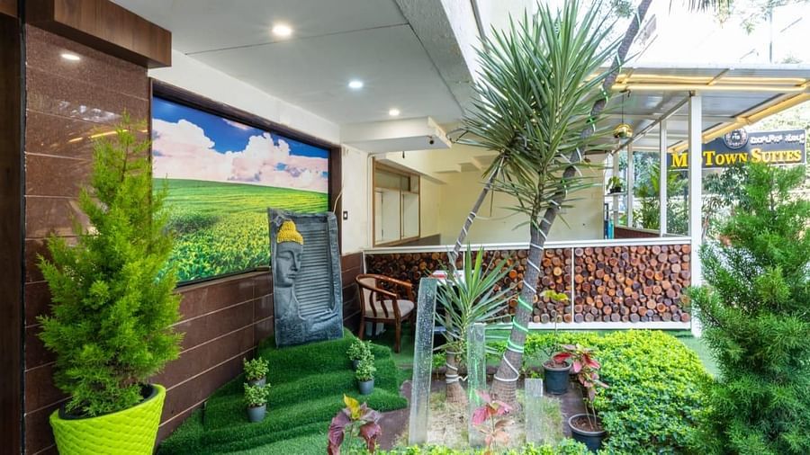 A beautifully landscaped outdoor area with a small fountain and greenery offers a refreshing escape at Lords Midtown Suites.