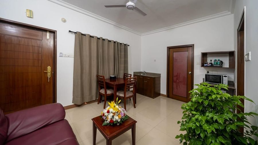 A comfortable living room with a sofa and wooden furniture offers a relaxing space for guests at Lords Midtown Suites.