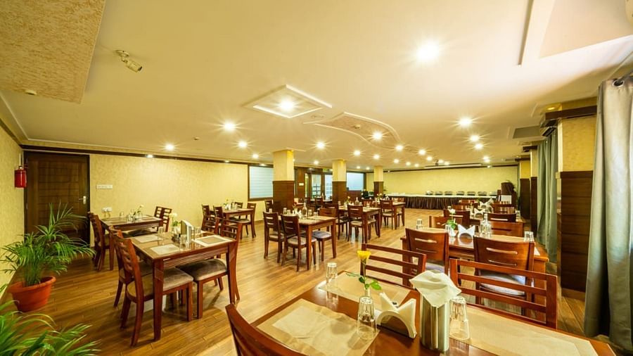 A spacious dining area with wooden furniture and warm lighting creates an inviting atmosphere at Lords Midtown Suites.
