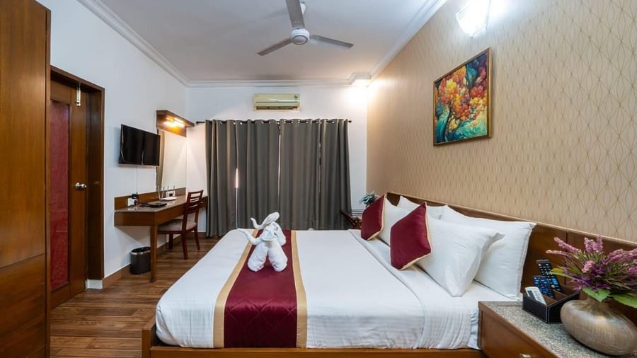 A well appointed bedroom features a comfortable bed with elegant linen and artistic decor at Lords Midtown Suites.