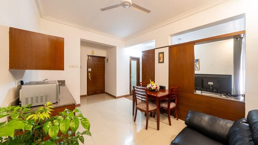 A spacious living area with comfortable seating and a dining table provides a homely feel at Lords Midtown Suites.