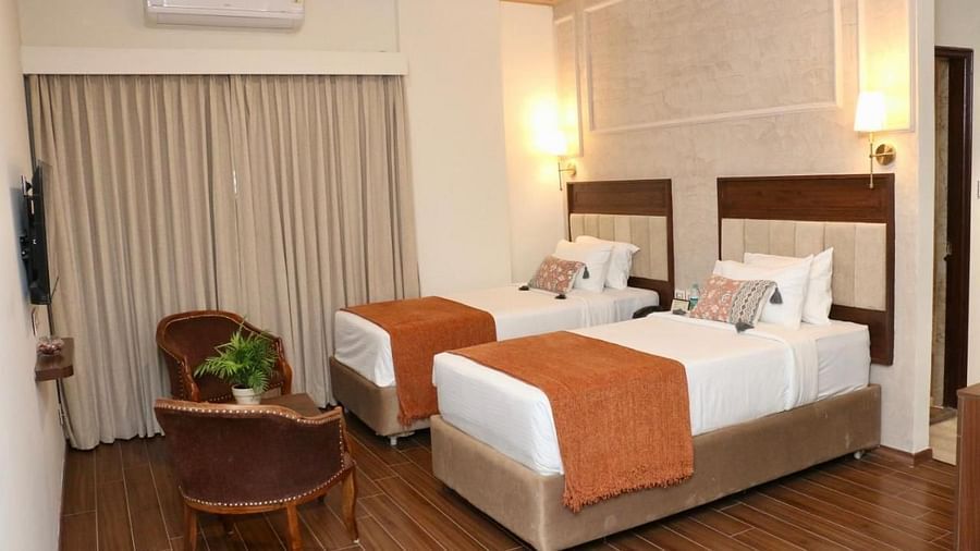 A Classic Twin Room at Nalapad Hotel Bangalore International with two beds and chairs.