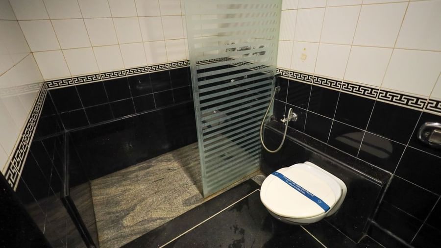 Modern bathroom with black tiled walls, glass shower enclosure, and white toilet at Paradise Isle Beach Resort.