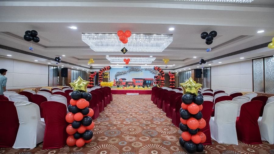 Event hall at Rang Lords Inn with decorated chairs, balloons, and a stage, prepared for a celebration