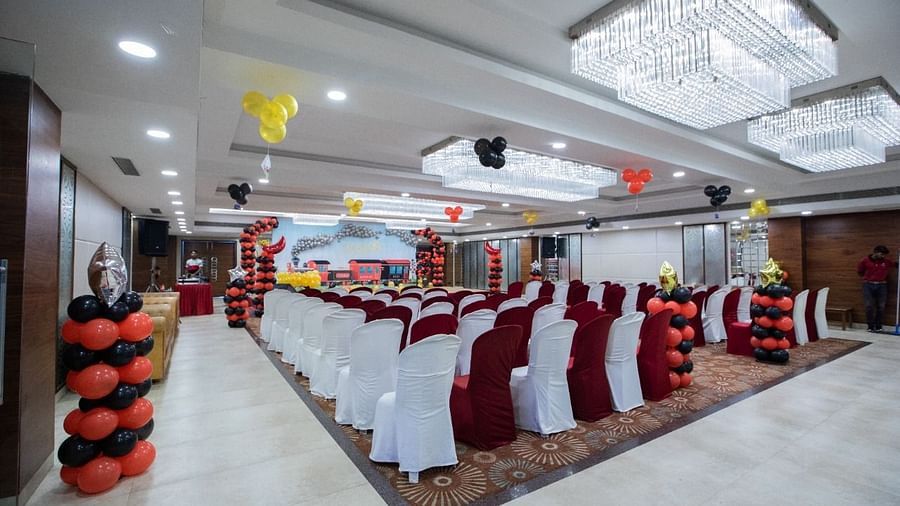 Event hall at Rang Lords Inn with a decorated aisle, chairs, balloons, and a chandelier, set for a gathering
