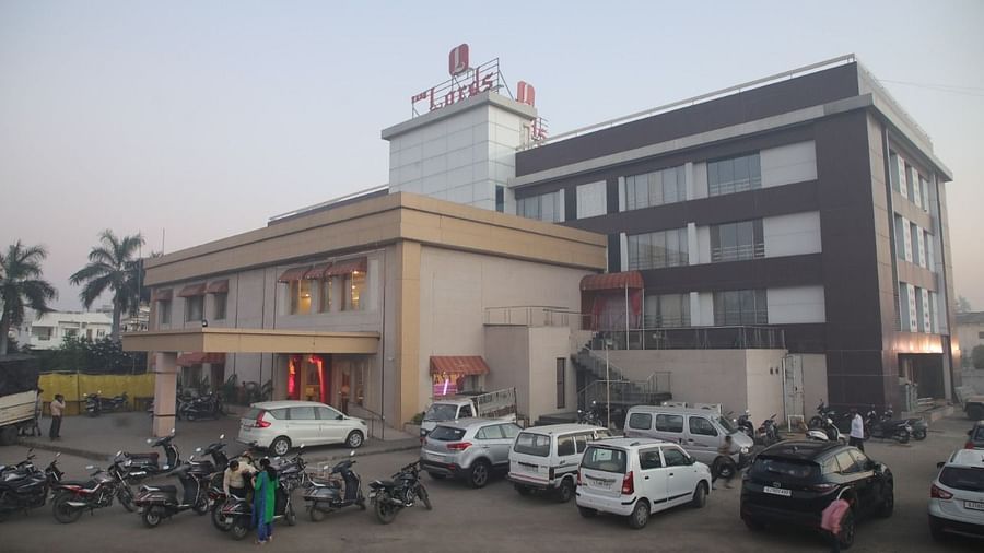  A facade image of Rang Lord Inn Bharuch featuring multi storey buildings and at the front yard there are vehicles parked