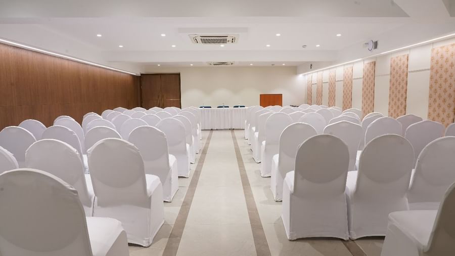 A spacious hall set up with rows of white chairs, ready for a large audience or presentation at Shilton Dee Cee.