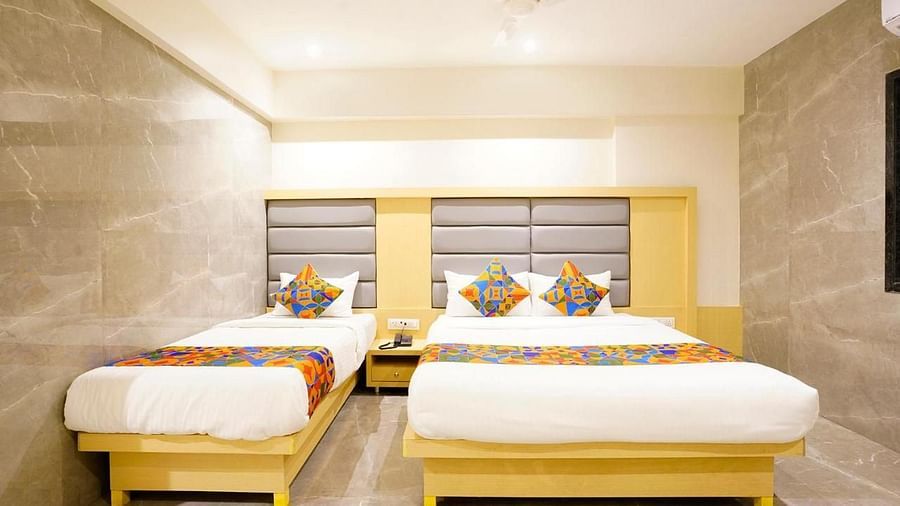 Hotel room with two single beds and modern bedside lighting - Shyanu Lords Eco Inn Airoli