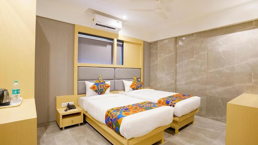 Hotel room with two single beds, bedside tables, and a window - Shyanu Lords Eco Inn Airoli