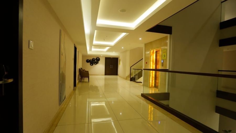 A pathway  with a lift, stairs, and a sitting area at The Hamuse Hotel, Kodaikanal.