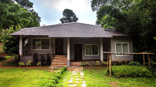 A charming cottage nestled amidst lush greenery, featuring a rustic design and a peaceful setting. - Abad Brookside Lakkidi, Wayanad