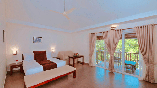 A double bed with side tables and lamps inside Garden cottage - Abad Brookside, Lakkidi