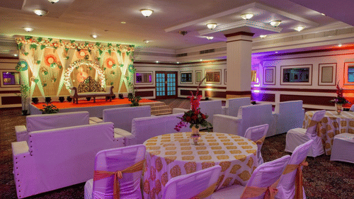 Nandi Hall at Clarks Khajuraho featuring a stage set up and cluster setting arrangement with tables and chairs.