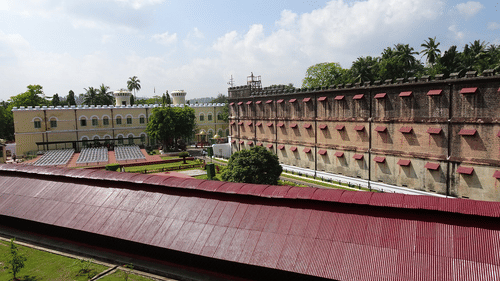 An overview of cellular jail in port blair with trees and blue sky in the background. It is the location of Light and Sound Show Port Blair.