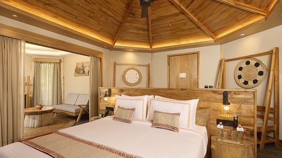 A villa in Chitwan featuring a double bed, a night stand, wooden ceiling and traditional decor - Royal Tulip, Chitwan