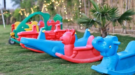 Colourful kids toy rides at inflated trampoline surrounded by trees at Themis Mudhouse - A Nature's Retreat Resort & Wellness