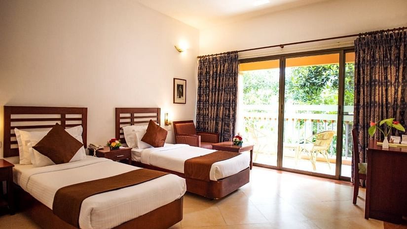 A resort bedroom with twin beds and a balcony 