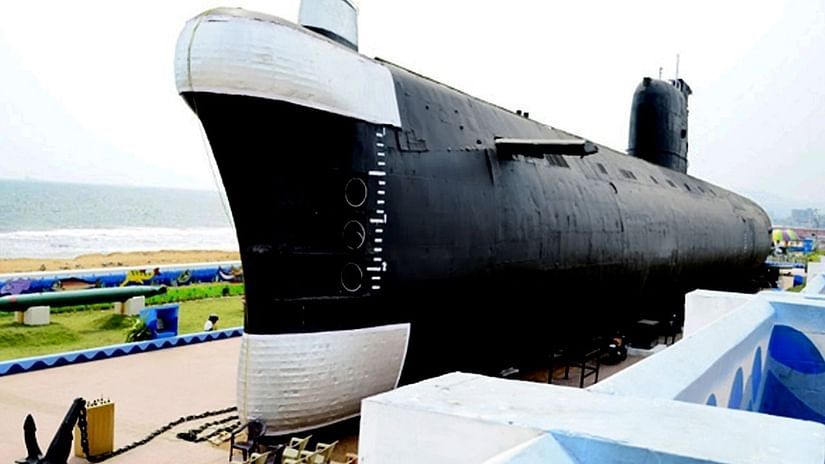 A large submarine displayed outdoors, with a walkway and a scenic background