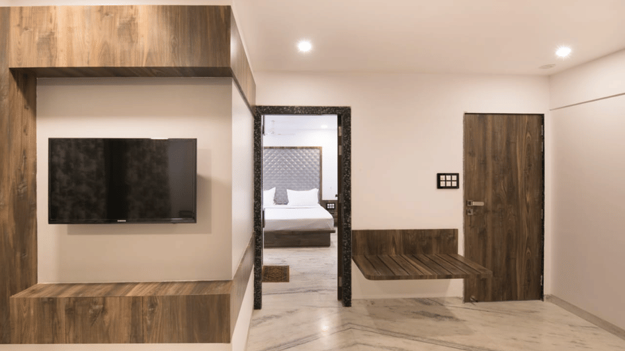 The living space of royal suite by sanmukh with its wooden interior and clean ambience.