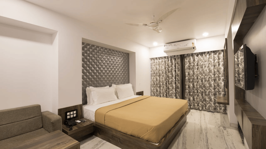 Super Deluxe room at Adamo Sanmukh with modern interior featuring a comfortable bed and clean ambience.