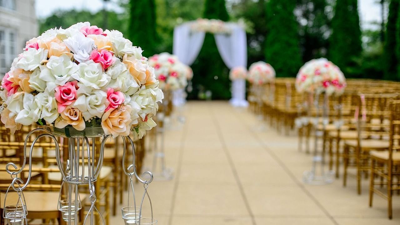Elegant outdoor wedding ceremony setup with floral arrangements and an aisle.